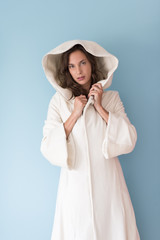 woman in a white coat with hood isolated on blue background