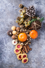 A set of Christmas decorations with tangerines, cookies over a stone background. Top view