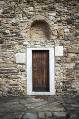 Ancient wooden door in stone castle wall.