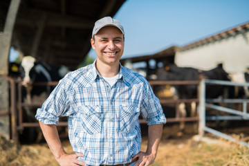 Smiling farmer in front of his cows