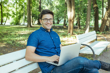 Young man with notebook sitting in the park