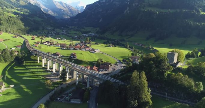Automotive and railway aqueduct in alpine foothill in Switzerland. Scenic peaceful view of countryside life. Top view of traditional swiss beautiful village. Vacation and european destination concept