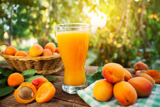 Glass with juice and fresh apricots