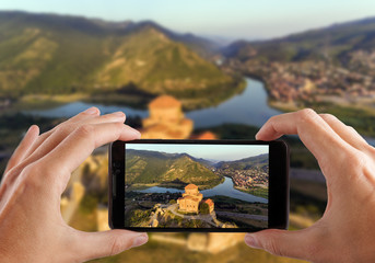 Travel concept. Hands making photo of Jvary monastery near Mtskheta, Georgia. © Dmytro Kosmenko