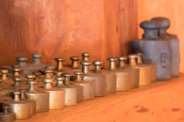 Obraz na płótnie Canvas Set of small brass weight units, wooden background,