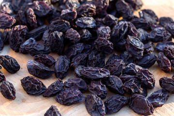 Prunes on wooden background, top view.