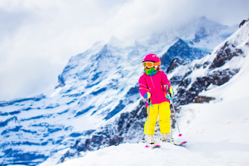 Fototapeta na wymiar Ski and snow fun. Child in winter mountains.