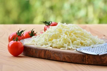 Fototapeten Grated mozzarella cheese and cherry tomatoes © whiteaster