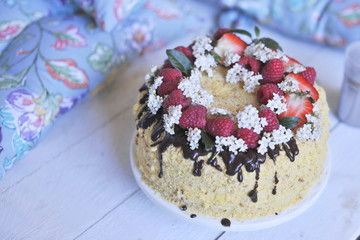 honey cake, decorated with berries and chocolate. sweet family dinner. holiday cake. on the balcony breakfast