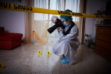 Forensics researcher photographing a blood  at a murder scene