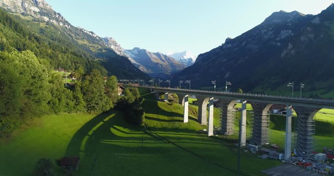 Automotive and railway aqueduct in alpine foothill in Switzerland. Scenic peaceful view of countryside life. Top view of traditional swiss beautiful village. Vacation and european destination concept