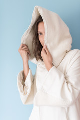 woman in a white coat with hood isolated on blue background