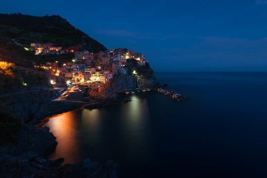 Stunning view of the beautiful and cozy village of Manarola in the Cinque Terre National Park at night. Liguria, Italy.