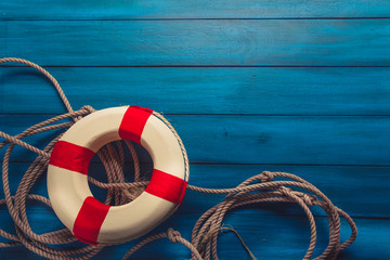 life saver with rope on a blue wooden background