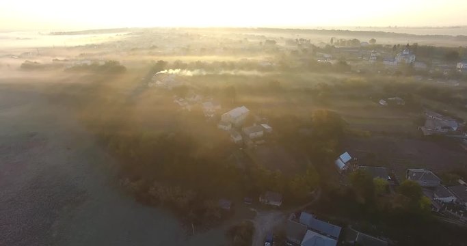 Air view of the village with fog, inium, church and river