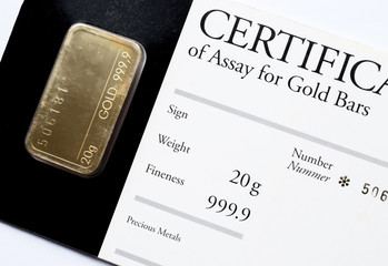 minted gold bar weighing 20 grams with certificate in a plastic blister.