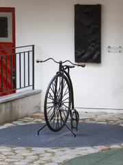 The old bicycle with one big and one small wheel in the yard in the old city, Tallinn..