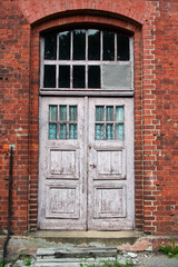 Antique door in the wall of red brick