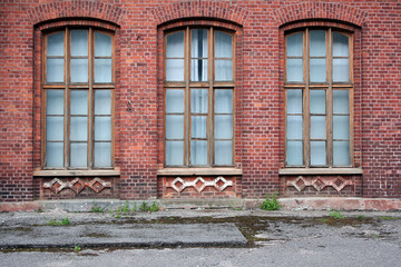 Fototapeta na wymiar Three antique windows in the wall of red brick