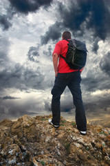 Man on the mountain edge. Tourist on the mountain edge and dark sky