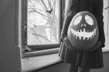 Creepy halloween scary pumpkin with a smile at the old wooden background doors