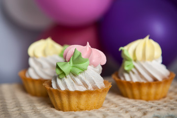 Colorful cupcakes with air balloons on background