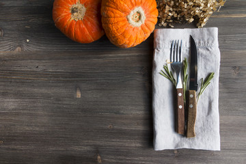 Thanksgiving, Halloween, food background - white wooden table with cutlery and pumpkins. Top view. Copy space.