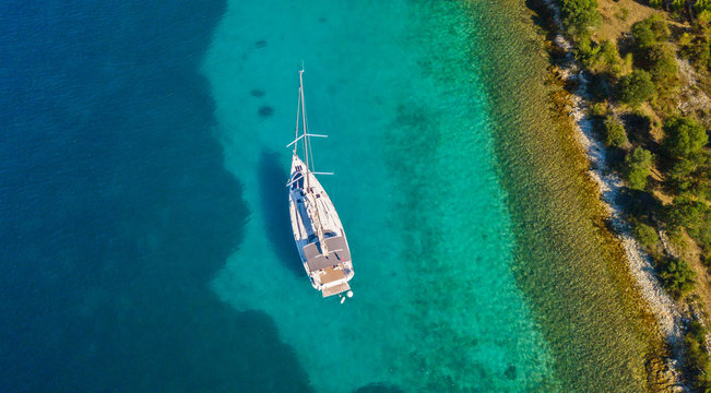 Aerial view of sailing boat anchoring next to reef