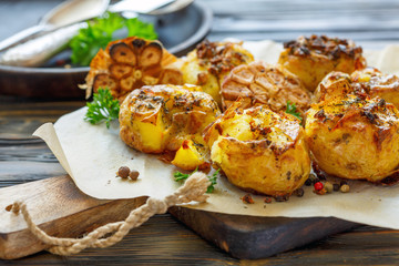 Baked potatoes in skin with spices, olive oil and garlic.