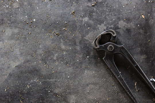 Pliers on dark metal background