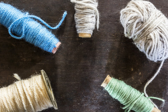 Different rolls of wool on dark metal background