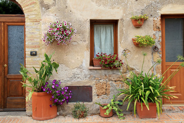 Fototapeta na wymiar old house decorated with flower pots in Tuscany, Italy