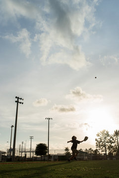 Boy stretching to catch a baseball