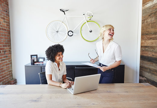 Portrait of millennial businesswomen in office laughing