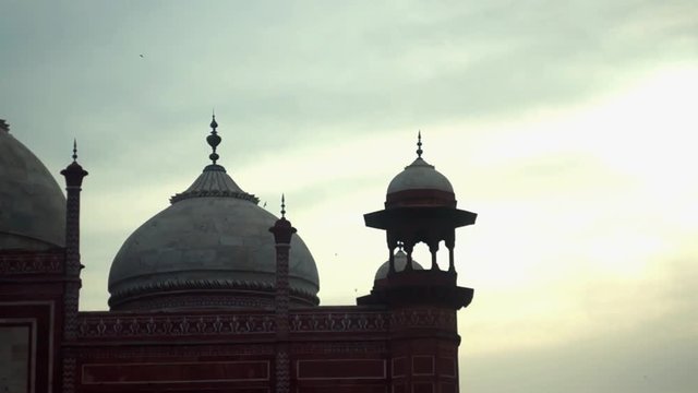 Canopy of the Jama Masjid set against a cloudy sky at sunset. The beauty of the mughal empire designed building is still appriciated by tourists who travel and explore india