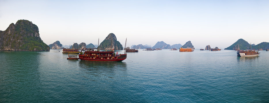 Stock Panoramic View Photo of Tourist Junk Boats in Halong Bay, Vietnam at Sunrise