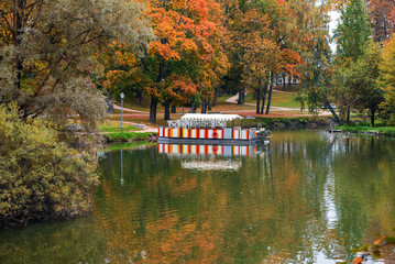 Obraz premium Small lake with wooden ferry in autumn park in Cesis town, Latvia