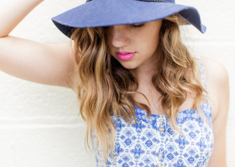 Close up of a teen girl in a blue hat with pink lips