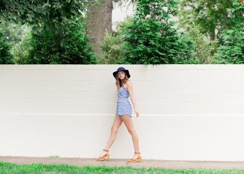 Teen Girl In Blue Romper And Hat Walking