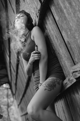 Young cutie with tattoo vaping outdoors