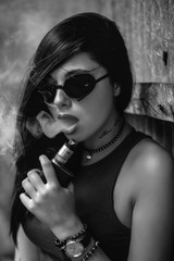 brunette in black sunglasses smokes vape