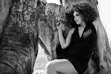 Ragazza con paesaggio marino e albero spoglio
