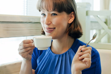 young woman in a cafe drinks coffee, concept of relaxation and coffee break.