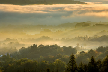 Fototapeta premium Unusual view of the autumn fog in the mountains at dawn.