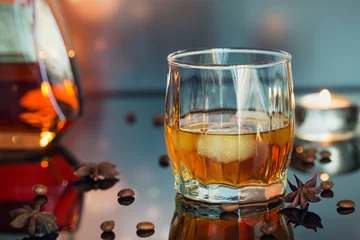 Papier Peint photo autocollant Alcool Cognac or liqueur, coffee beans and spices on a glass table.