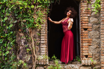 Fototapeta premium Bella ragazza con abito rosso in un castello abbandonato