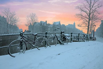 Tuinposter Sunset in snowy Amsterdam in the Netherlands in winter © Nataraj