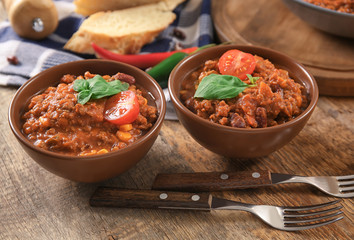 Bowls with delicious chili con carne on table