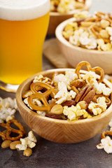 Homemade trail or snack mix with popcorn, pretzels and nuts with beer