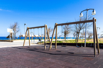 Children's safe wooden playground recreation area at seaside public park